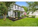 Charming two-story home with manicured lawn and a welcoming front porch surrounded by trees at 4236 Carrington Sw Ct, Concord, NC 28027