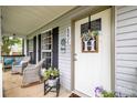 Inviting front porch with comfortable seating, decorative wreath, and well-maintained landscaping at 4236 Carrington Sw Ct, Concord, NC 28027