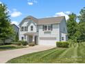 Well-manicured lawn and landscaping surround this light blue two-story home with a two-car garage at 4576 Fox Ridge Ln, Fort Mill, SC 29707