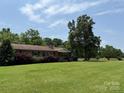 Single story home features a large front yard with mature trees, shrubs, and well-manicured lawn at 6018 Unionville Rd, Monroe, NC 28110