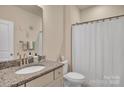 Cozy bathroom with granite countertop vanity and shower with white curtain at 608 Latrobe Dr, Iron Station, NC 28080