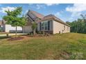 Exterior view showing a beautifully landscaped front yard with trees and green grass at 608 Latrobe Dr, Iron Station, NC 28080
