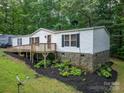 Charming home with a front porch, white siding, stone foundation, and surrounded by lush greenery at 6903 Knottywood Ln # 21, Vale, NC 28168