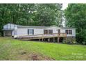 Charming home with a front porch, white siding, detached garage, and surrounded by lush greenery at 6903 Knottywood Ln # 21, Vale, NC 28168
