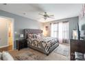 Serene main bedroom features a large upholstered bed, soft carpeting, and natural light, creating a peaceful retreat at 693 Carybrook Ct, York, SC 29745