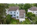 Aerial view of a light blue two-story house with a screened in porch and white picket fence at 720 Camaross Dr, Charlotte, NC 28270