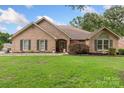 Attractive brick home featuring a lush green lawn, mature trees and welcoming curb appeal at 800 Isle Of Palms Ct, Fort Mill, SC 29708