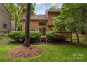 Spacious backyard featuring a two-story home with a deck surrounded by lush greenery and trees at 8968 St Croix Ln, Charlotte, NC 28277