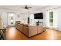 Bright living room featuring hardwood floors, a ceiling fan, and a comfortable sectional sofa at 943 Shinnville Rd, Mooresville, NC 28115