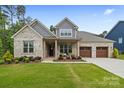 Charming brick home showcasing a manicured lawn and a welcoming three-car garage, blending style and functionality at 9833 Ardley Park Way, Mint Hill, NC 28227