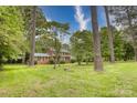 Charming two-story brick home surrounded by mature trees and lush green lawn on a sunny day at 1010 Forest Dr, Lancaster, SC 29720