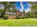 A two-story brick home on a well-manicured lawn under a blue sky on a sunny day at 1010 Forest Dr, Lancaster, SC 29720