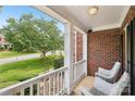 Relaxing front porch view with white columns, railings, wicker chairs, and a view of the front yard at 11103 Fountaingrove Dr, Charlotte, NC 28262