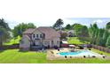 Expansive backyard featuring an in-ground pool, patio area, lush green lawn, and mature trees at 141 Weathers Creek Rd, Troutman, NC 28166