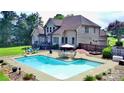 Backyard oasis with a large in-ground pool, patio area with dining set, and a well-maintained lawn at 141 Weathers Creek Rd, Troutman, NC 28166