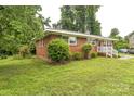 Cozy brick home with green lawn and mature trees, presenting a serene and well-kept exterior at 1631 Vancouver Dr, Charlotte, NC 28213