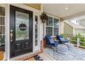 Inviting front porch with cozy seating, a stylish welcome sign, and decorative plants at 2010 Brightflower Ln, York, SC 29745
