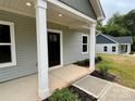 Inviting covered porch with sturdy white columns leading to a stylish black front door and meticulous landscaping at 212 Queens Ct, Gastonia, NC 28052