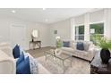 Bright living room boasts neutral tones, modern decor, large windows, and stylish furniture at 212 Queens Ct, Gastonia, NC 28052