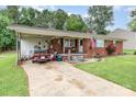 Charming one-story brick home featuring a covered carport, American flag, and quaint front porch at 2210 Joes Lake Rd, Shelby, NC 28152