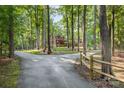 Scenic driveway leading to a beautiful log home surrounded by trees at 2709 Blythe Rd, Waxhaw, NC 28173