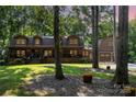 Charming log home boasts a covered porch and a detached garage among mature trees at 2709 Blythe Rd, Waxhaw, NC 28173