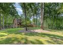 Well-manicured lawn and mature trees surrounding a cozy log cabin home at 2709 Blythe Rd, Waxhaw, NC 28173