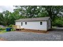 Rear exterior view with a small deck and gravel area at 2980 N Church St, Claremont, NC 28610