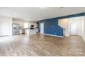 Bright, open-concept living area featuring wood-look flooring, modern lighting, and a bold accent wall at 3073 Langhorne Sw Ave, Concord, NC 28027