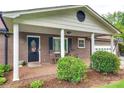 Inviting covered front porch with brick flooring, rocking chairs, and classic white columns and trim at 3447 Filbert Hwy, Clover, SC 29710