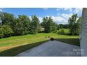 Spacious backyard with lush green lawn and a view of the trees and sky from a concrete patio at 347 Carolina Hemlock Dr, Locust, NC 28097