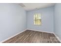 Bright bedroom with light-blue walls, wood-look floors and a window at 347 Carolina Hemlock Dr, Locust, NC 28097