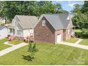 An aerial view showcasing the exterior of the home, highlighting its brick and siding accents and well-manicured lawn at 5111 Clearwater Rd, Charlotte, NC 28217