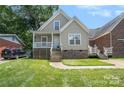 Inviting home with a covered porch and well-maintained lawn showcases classic curb appeal at 5111 Clearwater Rd, Charlotte, NC 28217