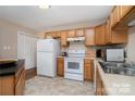 Efficient kitchen boasts wood cabinets, white appliances, and ample storage space at 5111 Clearwater Rd, Charlotte, NC 28217