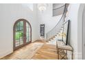 Bright foyer with hardwood floors, chandelier lighting, staircase, and arched entry at 5127 Lansing Dr, Charlotte, NC 28270