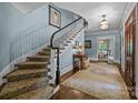 Elegant foyer with a curved staircase, hardwood floors, and stylish decor at 640 Colville Rd, Charlotte, NC 28207