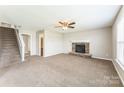 Inviting living room featuring plush carpeting, a ceiling fan, and a lovely stone fireplace at 673 Shellbark Dr, Concord, NC 28025