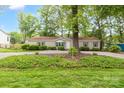 Beautiful home with lush landscaping, gravel driveway, and mature shade trees offering serene setting at 7232 Executive Cir, Denver, NC 28037
