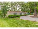 Charming home featuring manicured lawn, gravel driveway, and tasteful landscaping for welcoming curb appeal at 7232 Executive Cir, Denver, NC 28037