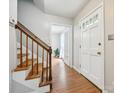 Bright entryway boasts hardwood floors, a staircase with wooden handrail, and natural light, creating a welcoming ambiance at 7317 Red Branch Ln, Charlotte, NC 28226