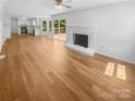 Bright, open-concept living space with hardwood floors, a fireplace, and access to a wooden deck at 7737 Batavia Ln, Charlotte, NC 28213