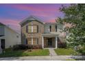 Two-story home featuring brick and siding, a front porch, black shutters, and a green lawn at 826 Sinclair Dr, Monroe, NC 28112