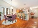 Open dining area with hardwood floors, modern lighting, and breakfast bar at 9348 Golden Pond Dr, Charlotte, NC 28269