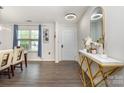 Inviting entryway featuring modern console table, light fixtures, wood flooring and blue-themed decor at 9524 Eagle Feathers Dr, Charlotte, NC 28214
