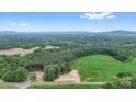 Expansive aerial view of the property showing the home surrounded by lush greenery and a mountain backdrop at 977 Myers Mill Rd, Olin, NC 28660