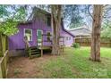 View of the backyard featuring a purple house, small wooden deck, and mature trees at 10 Cedarvilla Dr, Rock Hill, SC 29730