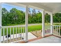 View from the cozy covered front porch with white columns and view of the landscaped yard at 1209 Rainbow Dr, Kannapolis, NC 28081