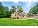 Charming home with a covered front porch, landscaped yard, and lush green lawn at 1209 Rainbow Dr, Kannapolis, NC 28081