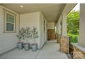 Inviting front porch featuring stone pillars, potted plants, and a neutral color palette for a warm welcome at 15344 Cimarron Hills Ln, Charlotte, NC 28278